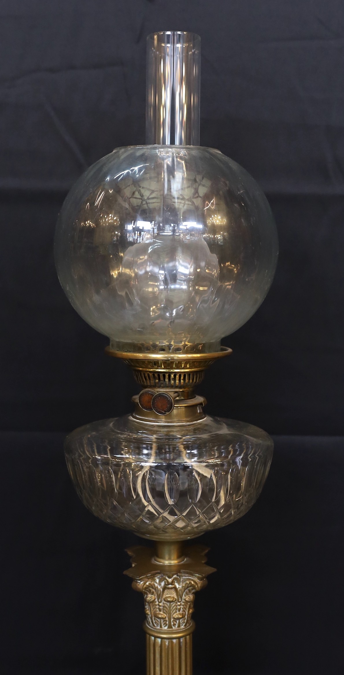 A late Victorian/Edwardian Corinthian column brass oil lamp, with cut glass reservoir, J.R.Roberts mechanism, fluted glass globe and flue, height overall 83cm